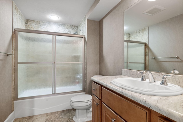 bathroom with enclosed tub / shower combo, visible vents, vanity, and toilet