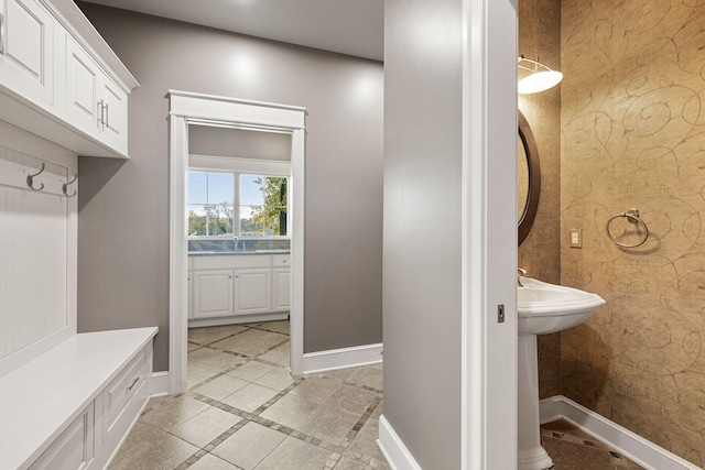 mudroom featuring baseboards and wallpapered walls