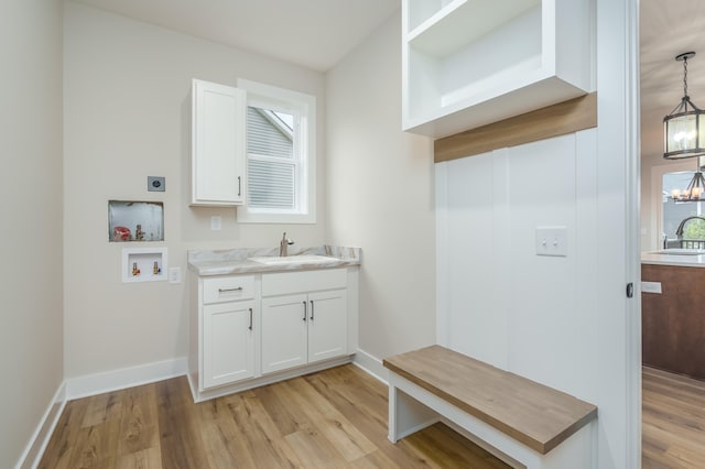 laundry area featuring light hardwood / wood-style flooring, a notable chandelier, and sink