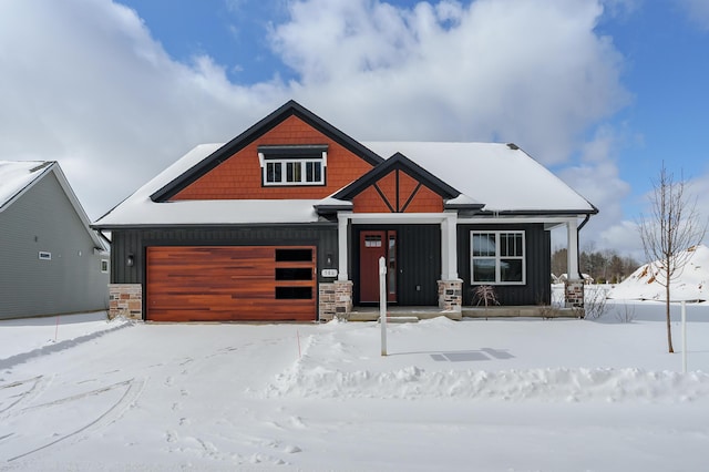 view of front of house with board and batten siding, stone siding, and a garage