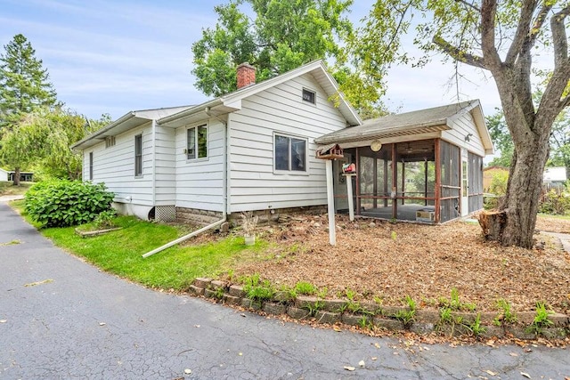 view of side of home featuring a sunroom