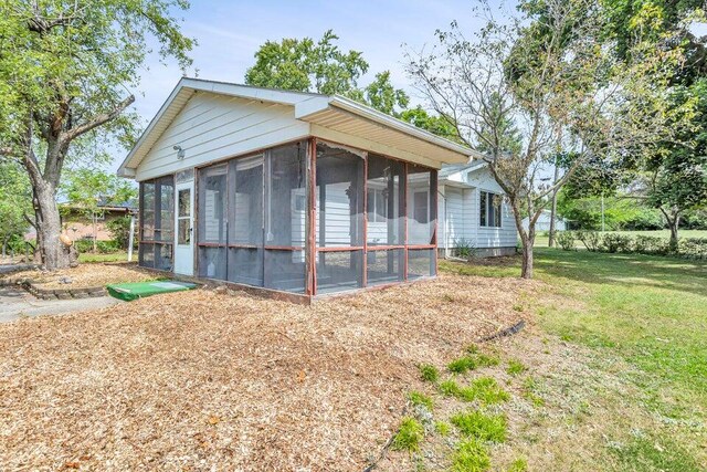 exterior space with a sunroom and a yard