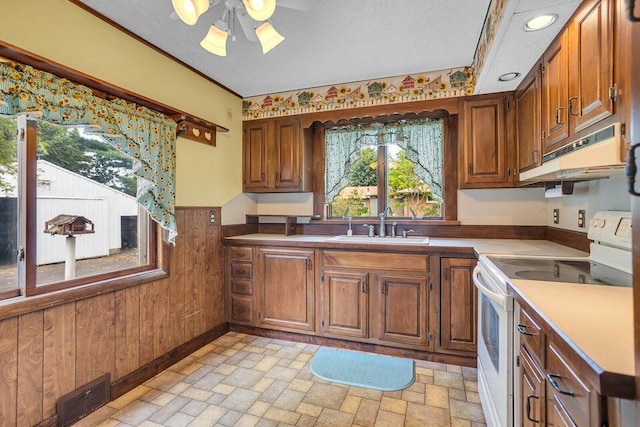 kitchen featuring ceiling fan, sink, white electric range oven, extractor fan, and wooden walls