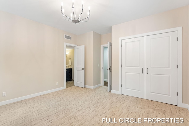 unfurnished bedroom featuring light hardwood / wood-style flooring, an inviting chandelier, and a closet