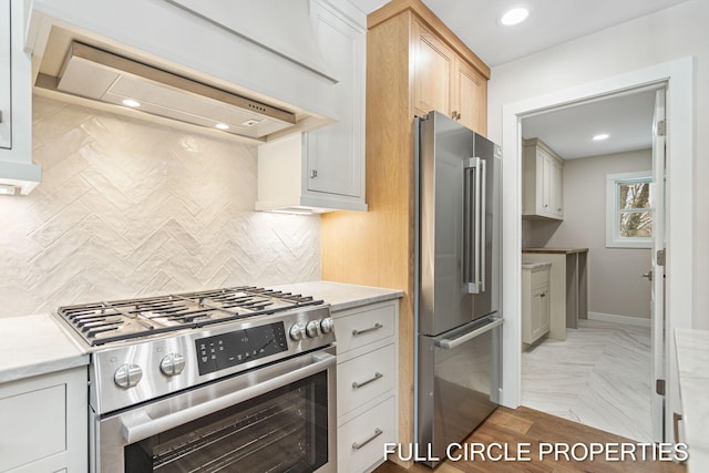 kitchen featuring light brown cabinetry, backsplash, custom exhaust hood, high end appliances, and white cabinetry