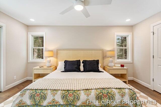 bedroom with multiple windows, wood-type flooring, and ceiling fan