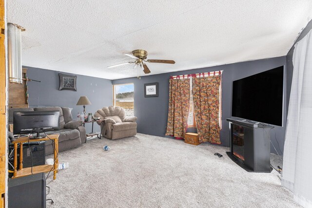 living room with ceiling fan, carpet floors, and a textured ceiling