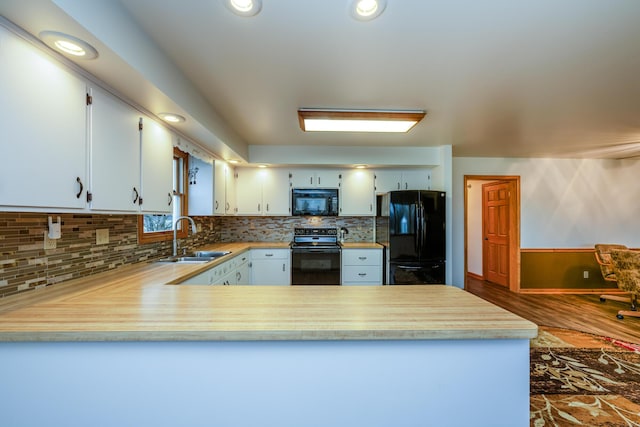 kitchen with backsplash, black appliances, sink, dark hardwood / wood-style flooring, and kitchen peninsula