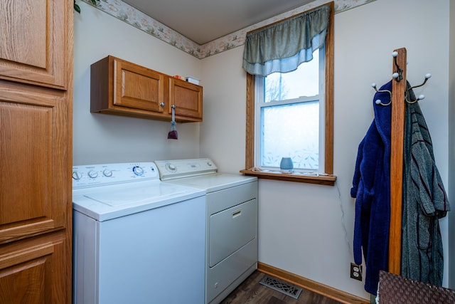 washroom with washing machine and clothes dryer, cabinets, and dark hardwood / wood-style floors