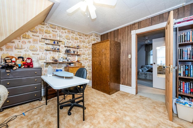 office space featuring carpet, ceiling fan, and wooden walls