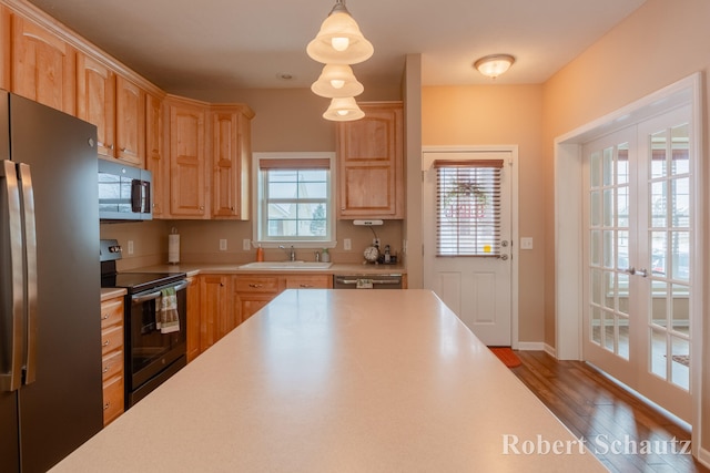 kitchen featuring pendant lighting, stainless steel appliances, a wealth of natural light, and french doors