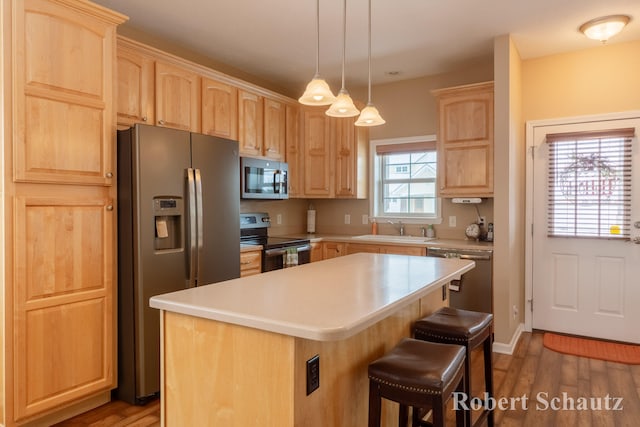 kitchen featuring hardwood / wood-style floors, a center island, sink, and stainless steel appliances