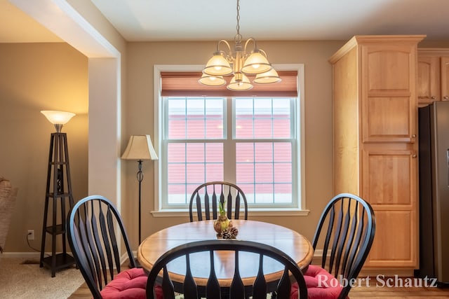 dining area with carpet flooring, an inviting chandelier, and plenty of natural light