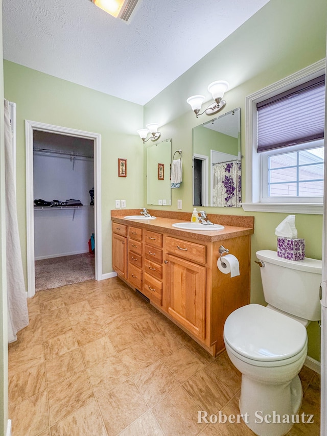 bathroom with vanity, a textured ceiling, and toilet