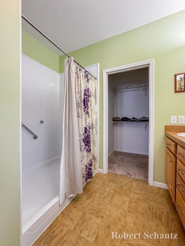 bathroom featuring a shower with curtain, vanity, and a textured ceiling