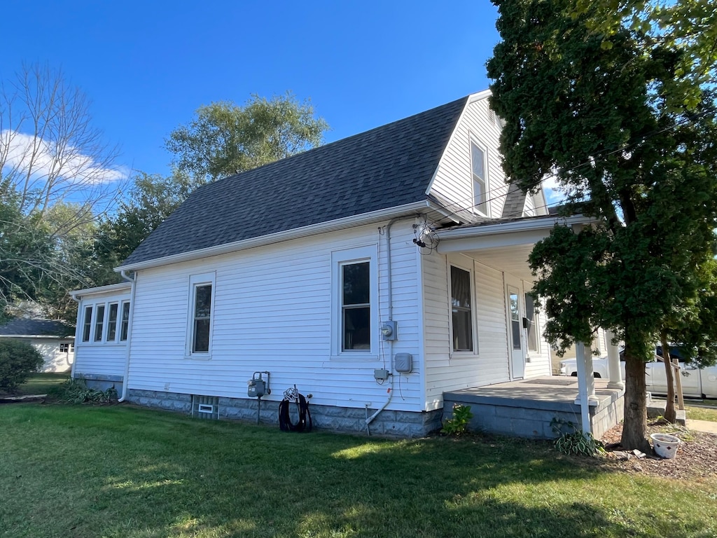 view of side of property featuring a yard and covered porch