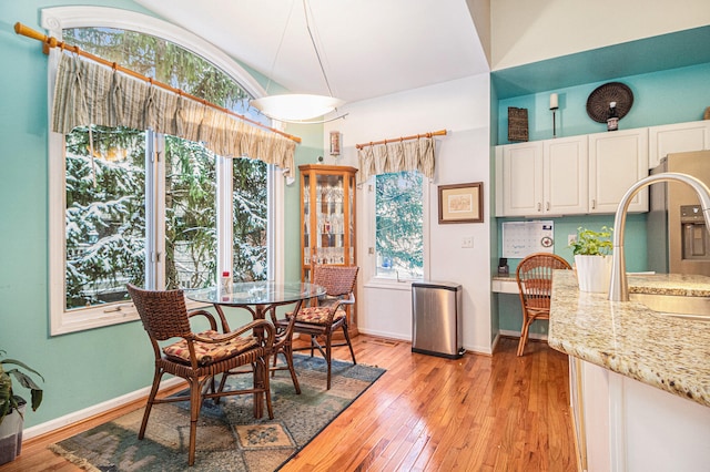 dining space with sink, a wealth of natural light, and light hardwood / wood-style flooring