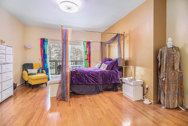 bedroom with access to exterior and light hardwood / wood-style floors