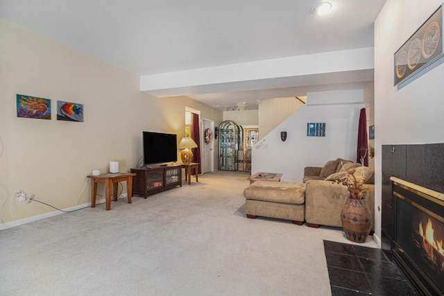 living room with carpet flooring and a tiled fireplace