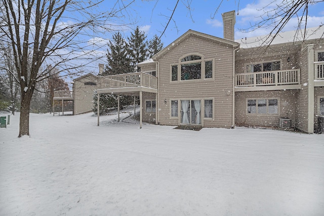 snow covered house featuring cooling unit