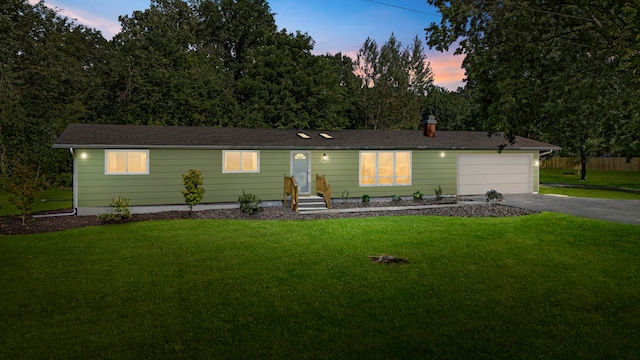 view of front of home with a garage and a yard