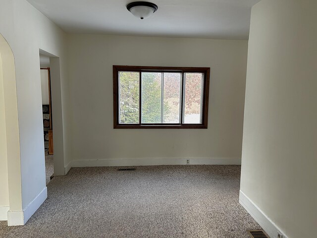 unfurnished room featuring light colored carpet