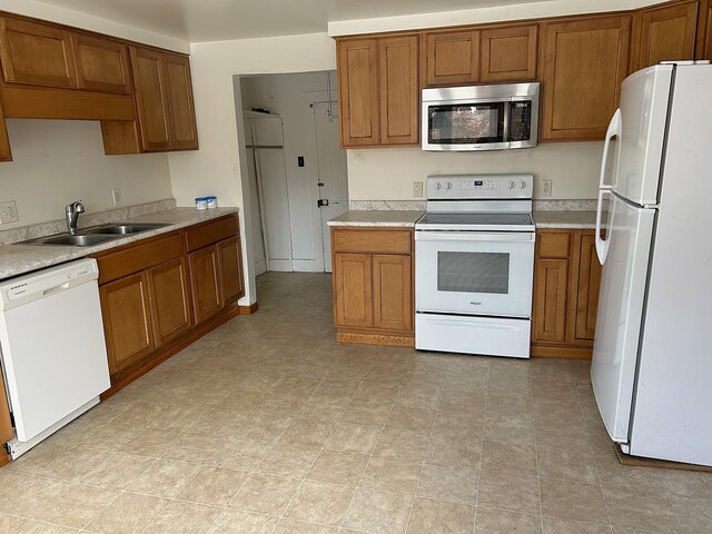 kitchen featuring white appliances and sink