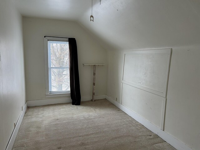 bonus room featuring a healthy amount of sunlight, light carpet, and vaulted ceiling