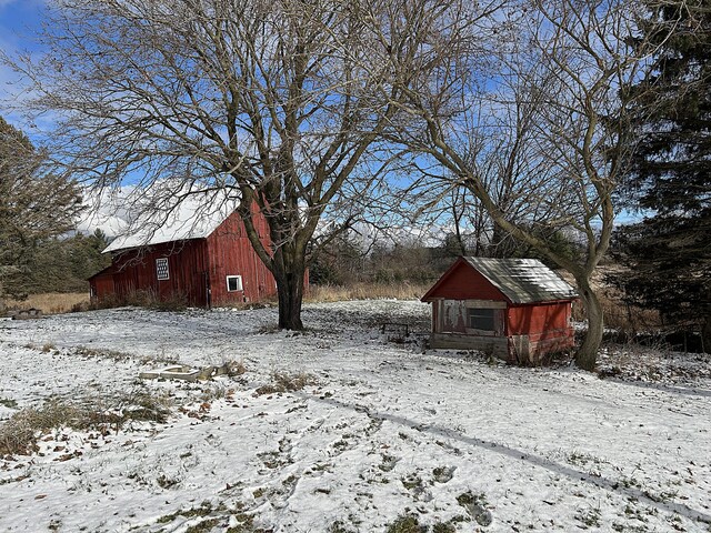 snowy yard with an outbuilding