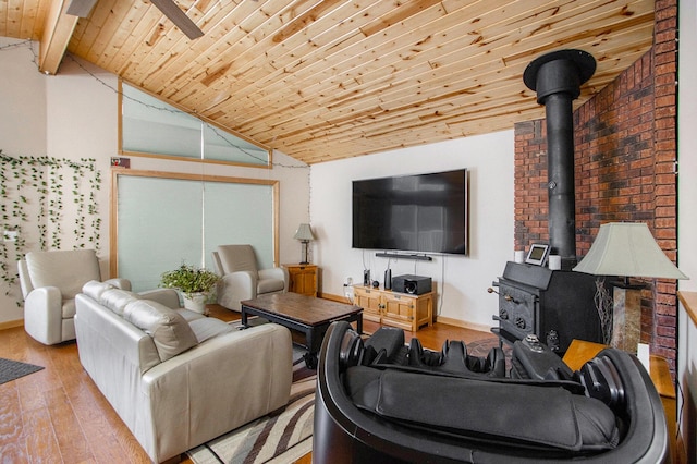 living room featuring wooden ceiling, vaulted ceiling with beams, a wood stove, and light hardwood / wood-style flooring