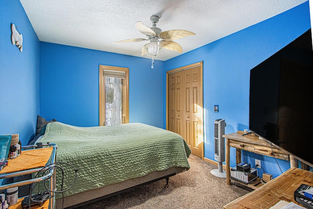 bedroom with carpet flooring, ceiling fan, a textured ceiling, and a closet