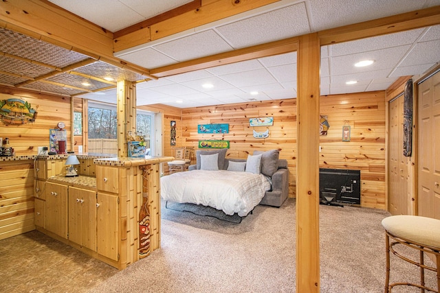 carpeted bedroom featuring wood walls