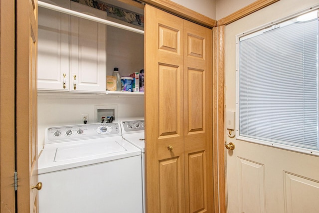 clothes washing area with cabinets and independent washer and dryer