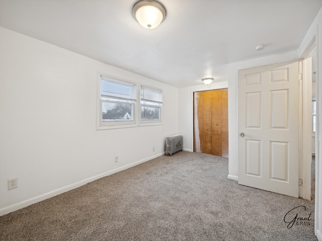 unfurnished bedroom featuring carpet and radiator