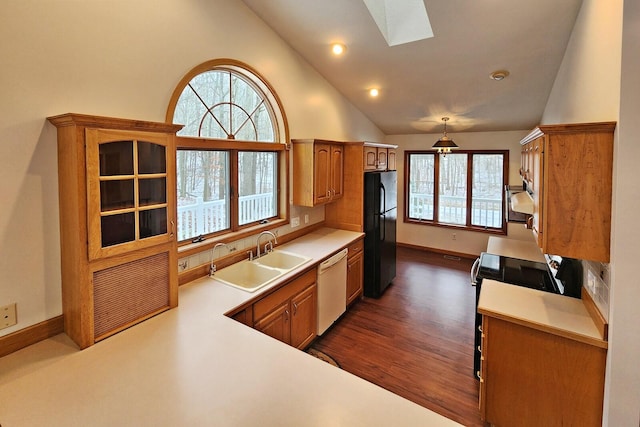 kitchen with a skylight, dark wood-type flooring, sink, black appliances, and pendant lighting