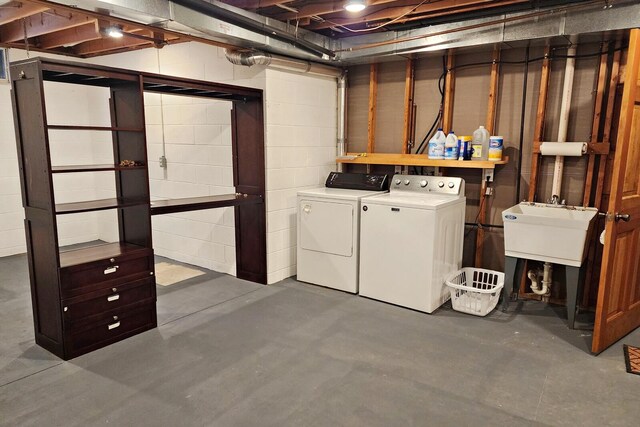 basement featuring washing machine and clothes dryer and sink