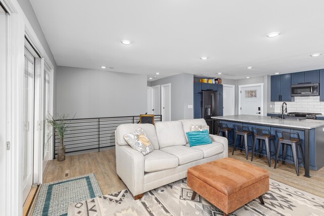 living room with sink and light wood-type flooring