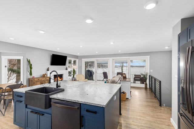 kitchen with light hardwood / wood-style flooring, an island with sink, stainless steel appliances, and sink