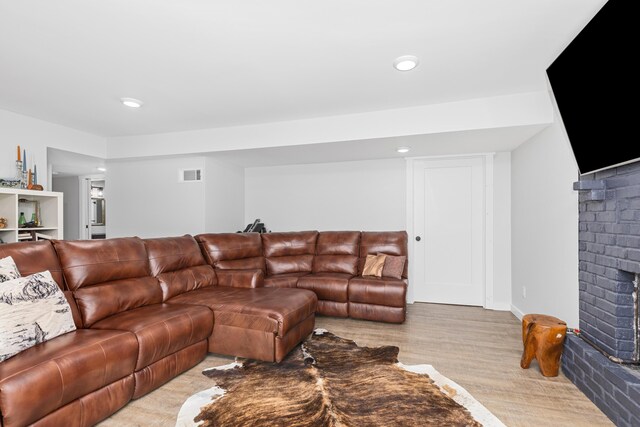 living room with a fireplace and light hardwood / wood-style flooring