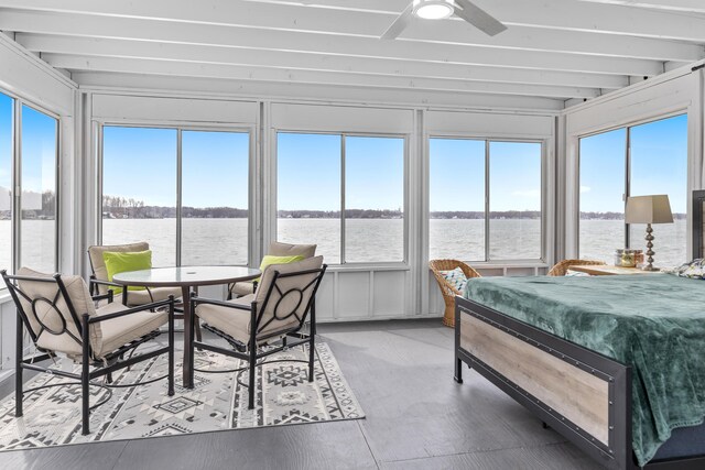 sunroom / solarium featuring ceiling fan and a water view