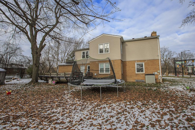 snow covered house featuring a trampoline