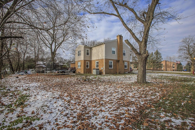 snow covered property featuring a trampoline and central AC