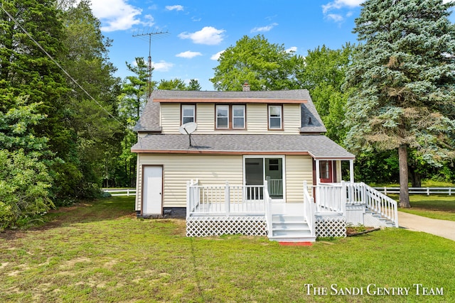 rear view of property featuring a lawn and a wooden deck