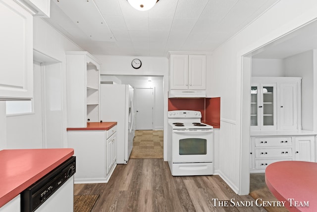 kitchen featuring crown molding, white cabinets, dark wood-type flooring, and white appliances