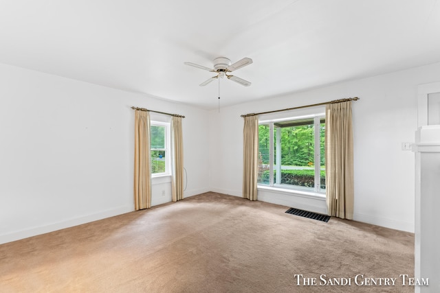 carpeted spare room with ceiling fan and a healthy amount of sunlight