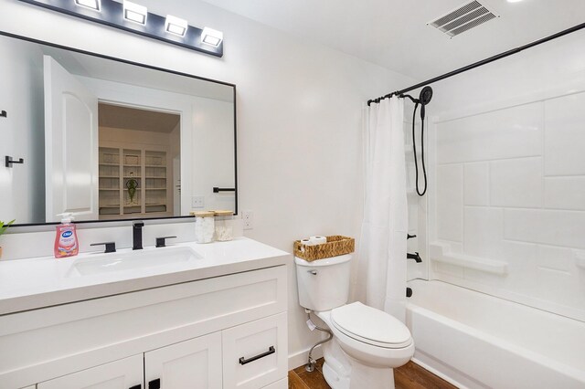 full bathroom with hardwood / wood-style floors, vanity, toilet, and shower / tub combo