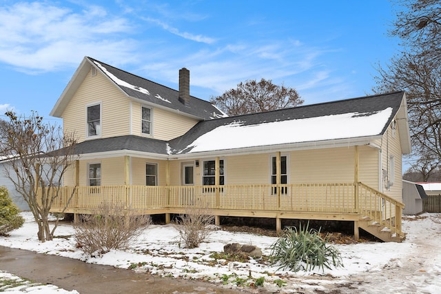 view of snow covered back of property