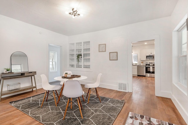 dining space with hardwood / wood-style floors and a wealth of natural light