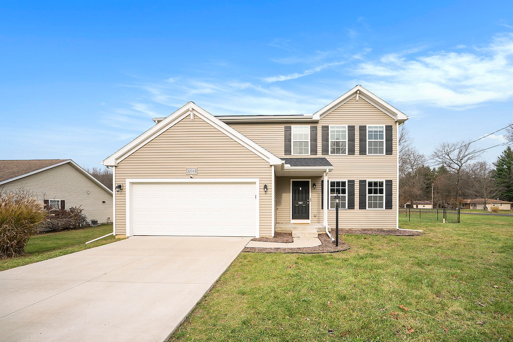 view of front of house with a garage and a front lawn