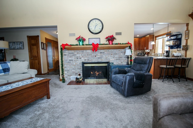 living room with carpet and a brick fireplace